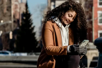 Cheerful ethnic woman browsing smartphone