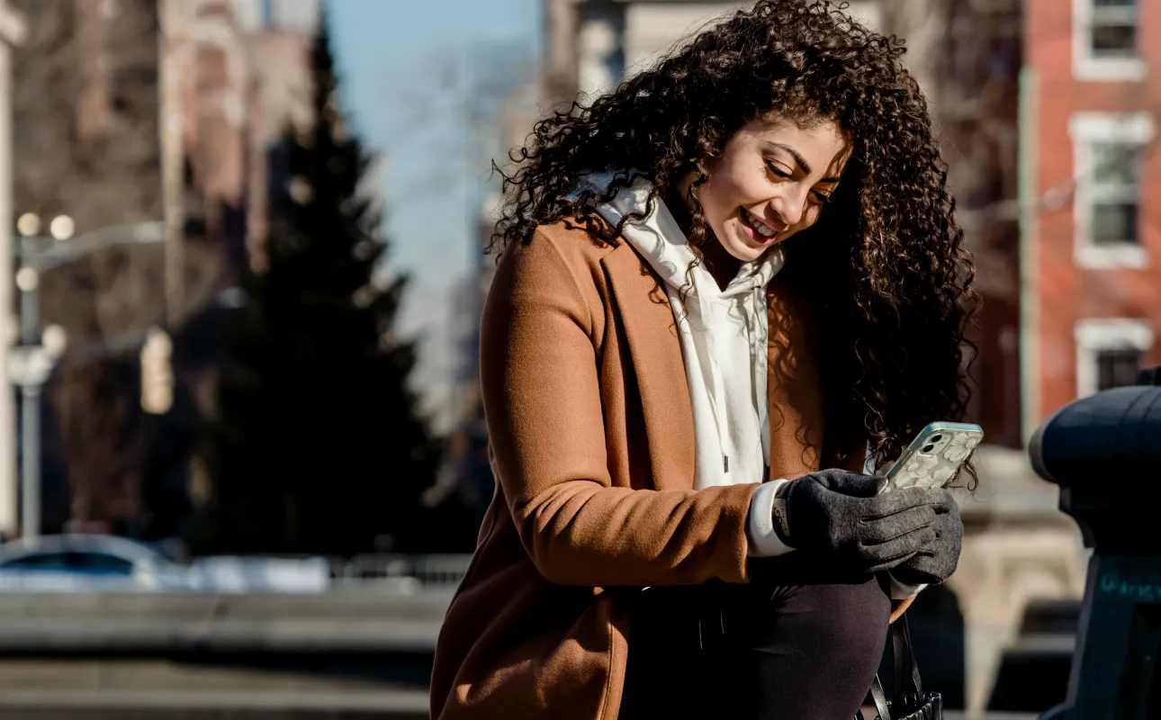 Cheerful ethnic woman browsing smartphone