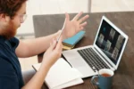 A man having a conference call on his laptop with his team at different remote location