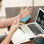 A man having a conference call on his laptop with his team at different remote location
