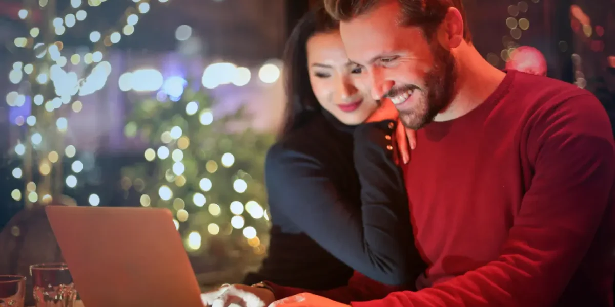 Happy couple shopping online on laptop