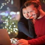 Happy couple shopping online on laptop
