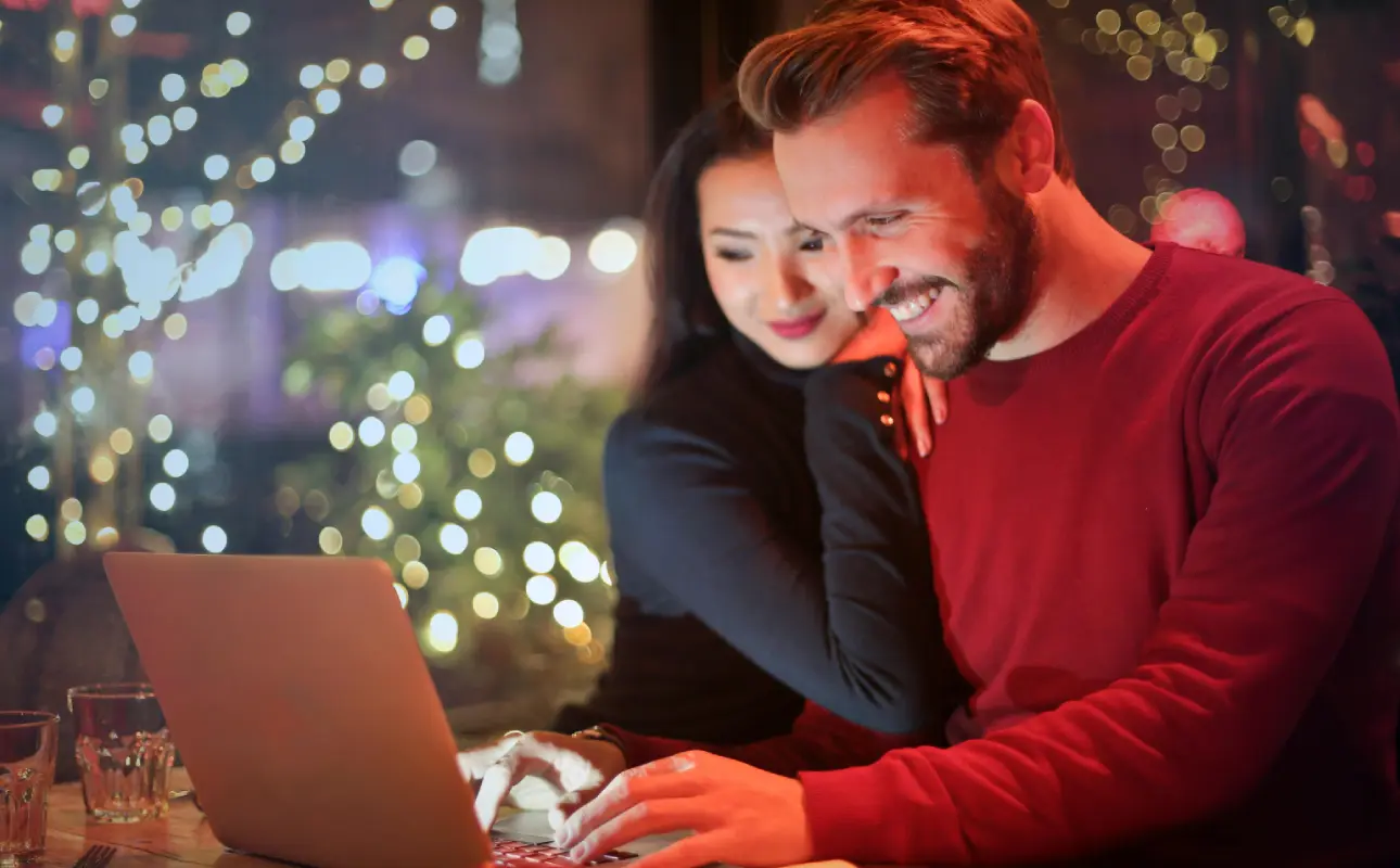 Happy couple shopping online on laptop