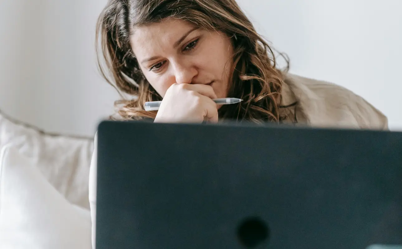 A woman entrepreneur looking at her laptop with a worrying look