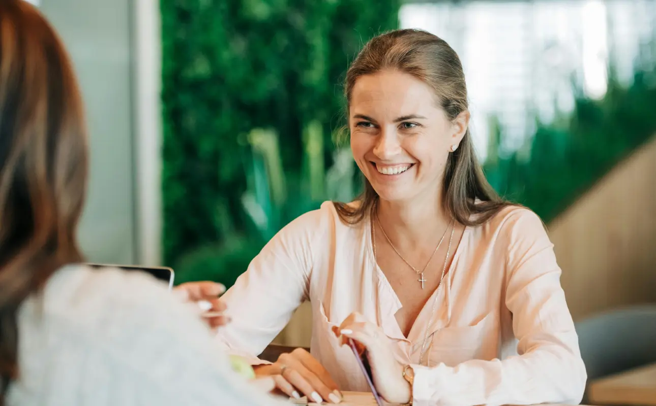 UX Designer Taking User Feedback. Two women sitting across the table and talking.